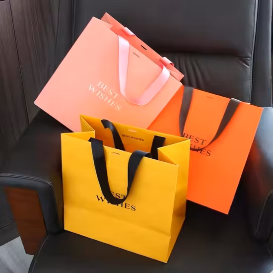 Logo personnalisé en gros imprimé nouveau Design sac cadeau poignée découpée sac de papier commercial noir avec Logo d'estampage de feuille d'or